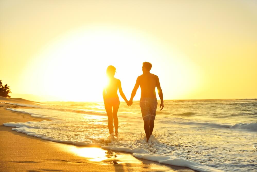 newlywed couple walking on beach during sunset on kauai for their honeymoon